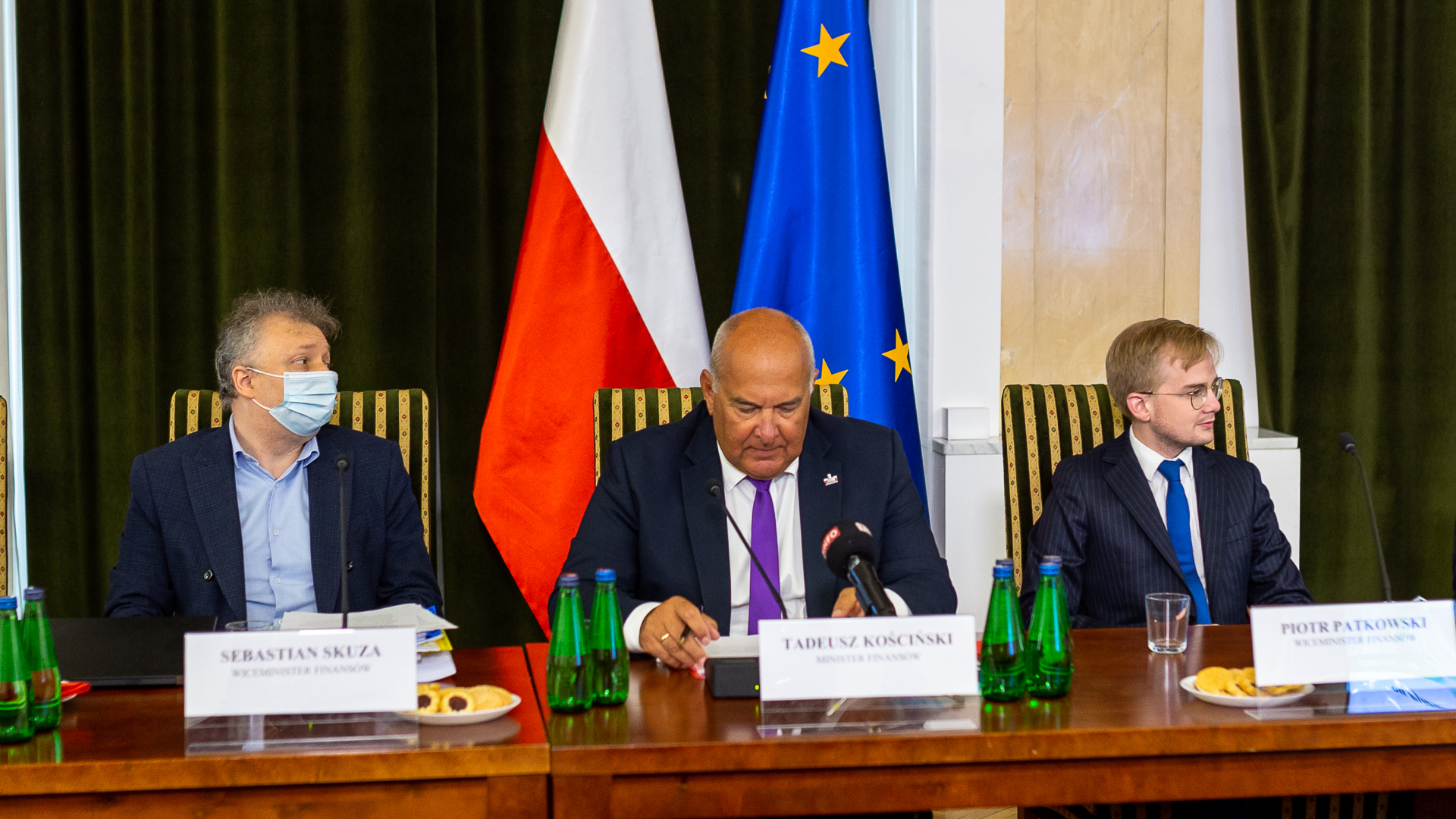 Stół prezydialny, przy którym siedzą od lewej: wiceminister Sebastian Skuza, minister finansów Tadeusz Kościński, wiceminister Piotr Patkowski.