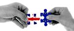 dłonie trzymające dwa puzzle z flagami: brytyjską i unijną